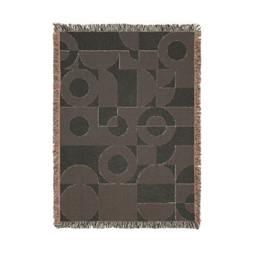 Geometric patterned throw blanket with circular and square shapes on a dark background